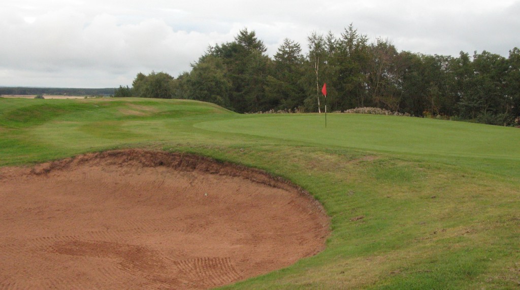 The greenside bunker at the left of 14th, a natural target with OOB all down the right.
